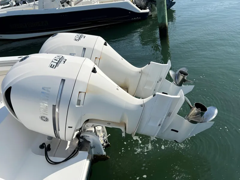 Slide: The Image of Twin Yamaha outboard engines on a 2013 Jupiter 30 FS boat, docked in calm waters. - 49