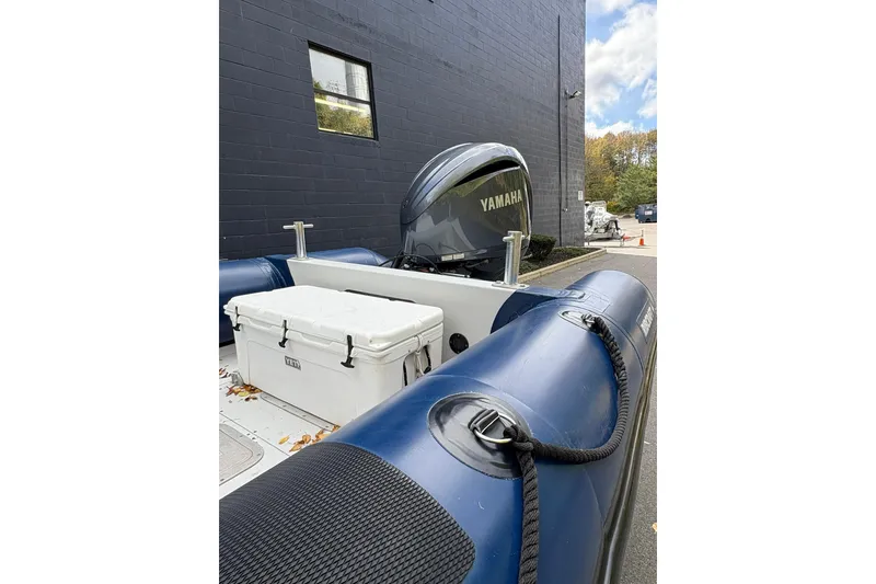 Slide: The Image of 2019 Ribcraft 7.8 boat with Yamaha engine and Yeti cooler, docked outdoors. - 10