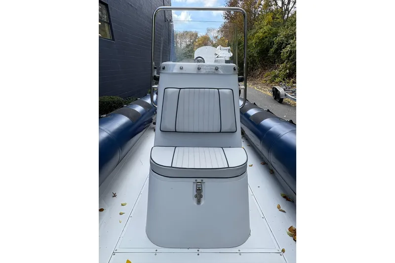 Slide: The Image of 2019 Ribcraft 7.8 boat with cushioned seating, docked outdoors. - 6