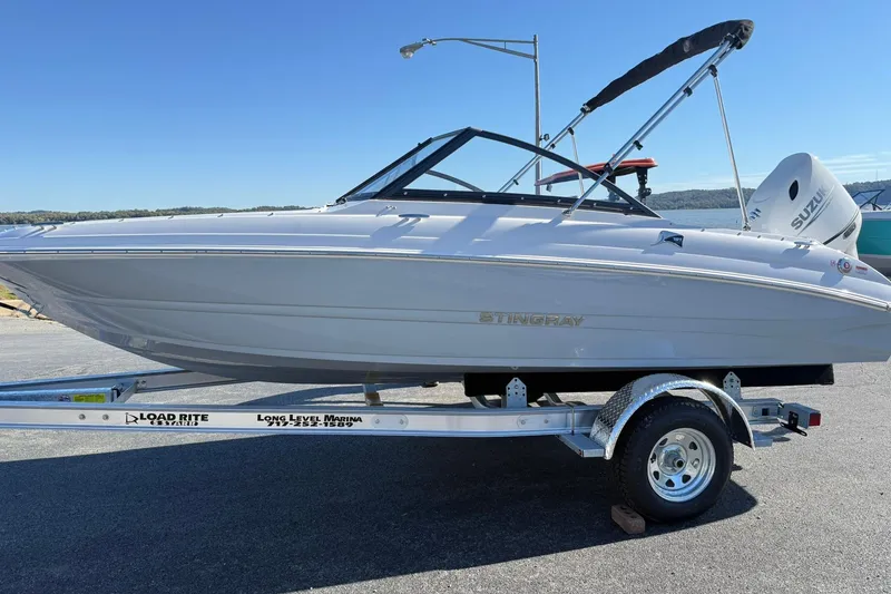 The Image of 2026 Stingray 191 DC boat on trailer, sunny day, clear sky background. - 1