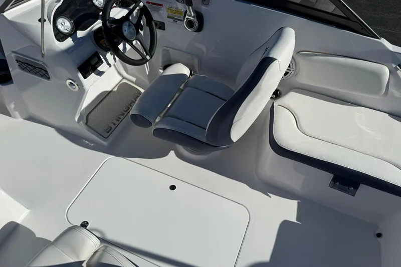 Slide: The Image of 2026 Stingray 191 DC boat interior with white seating and steering console. - 12