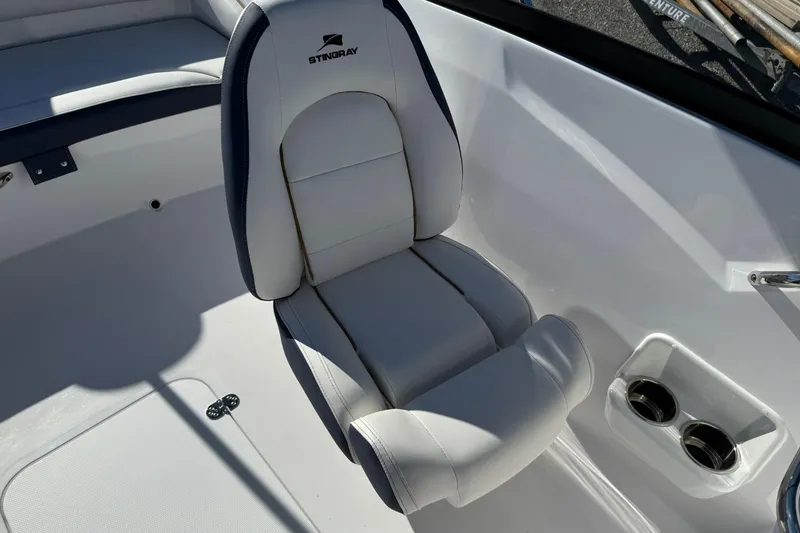 Slide: The Image of 2026 Stingray 191 DC boat interior with white cushioned seat and cup holders. - 18