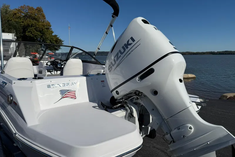 Slide: The Image of 2026 Stingray 191 DC boat with Suzuki outboard motor by a lake. - 3