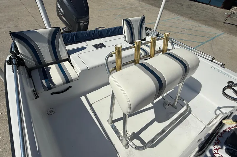 Slide: The Image of 2007 Champion 22 Bay Champ boat interior with Yamaha 200 engine, featuring striped seating and rod holders. - 13