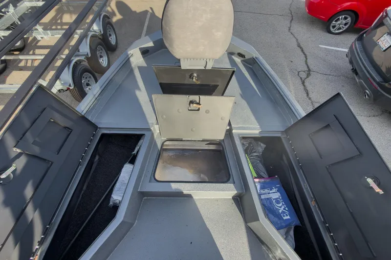 Slide: The Image of 2026 Excel Bay Pro Elite 220 boat interior with open storage compartments and seating. - 18