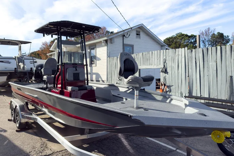 The Image of 2026 Excel Bay Pro Elite 220 boat on trailer, parked outdoors near a wooden fence. - 2