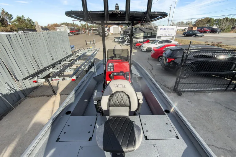 Slide: The Image of 2026 Excel Bay Pro Elite 220 boat with seating, parked at dealership. - 20
