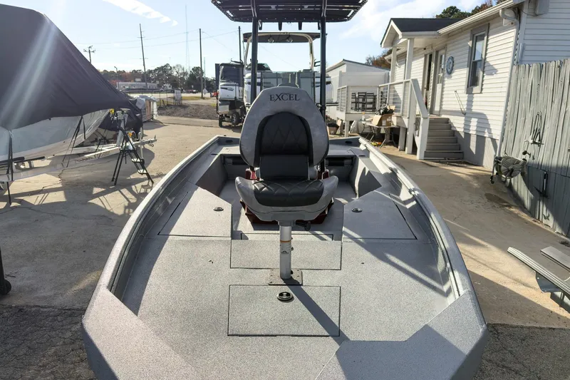 Slide: The Image of 2026 Excel Bay Pro Elite 220 boat displayed outdoors at a dealership. - 26