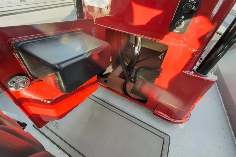 Slide: The Image of 2026 Excel Bay Pro Elite 220 boat interior with red console and storage compartment. - 27