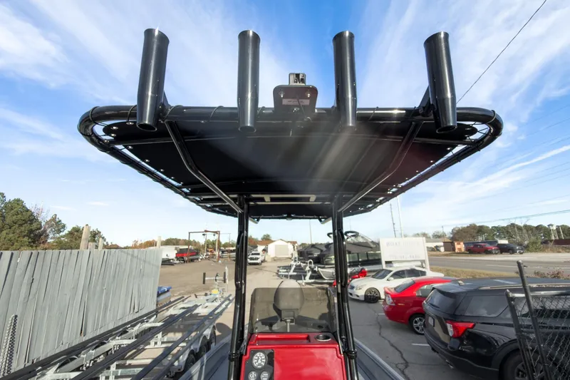 Slide: The Image of 2026 Excel Bay Pro Elite 220 boat with T-top and rod holders in a parking lot. - 7