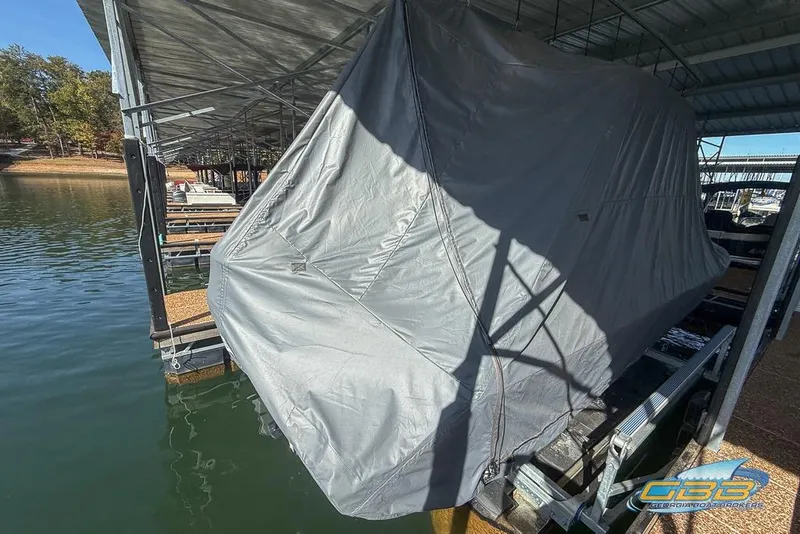 Slide: The Image of Covered 2023 Robalo 226 Cayman boat docked under a shelter. - 10