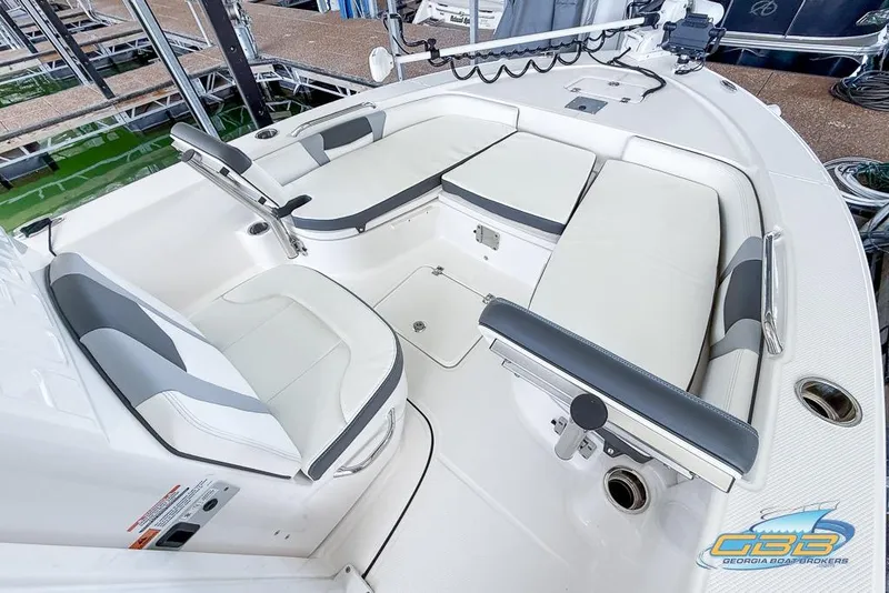 Slide: The Image of 2023 Robalo 226 Cayman boat interior with white and gray seating, docked at marina. - 12
