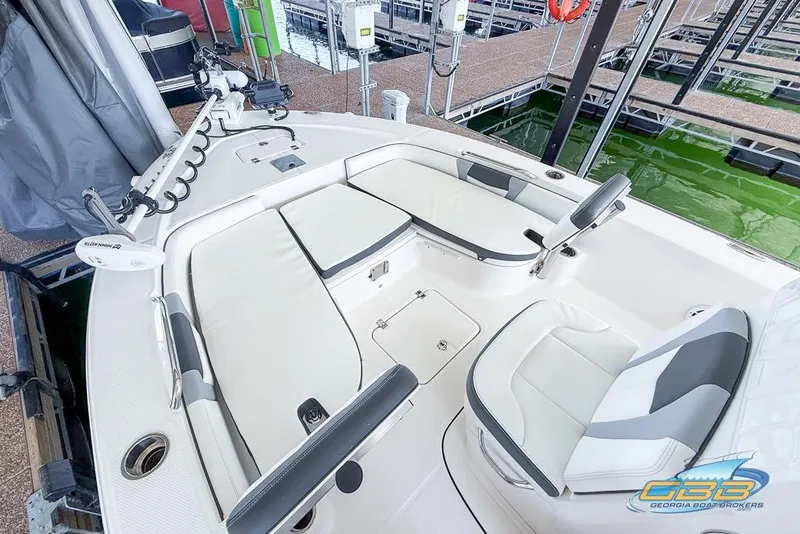 Slide: The Image of 2023 Robalo 226 Cayman boat interior with white seating and fishing equipment. - 13
