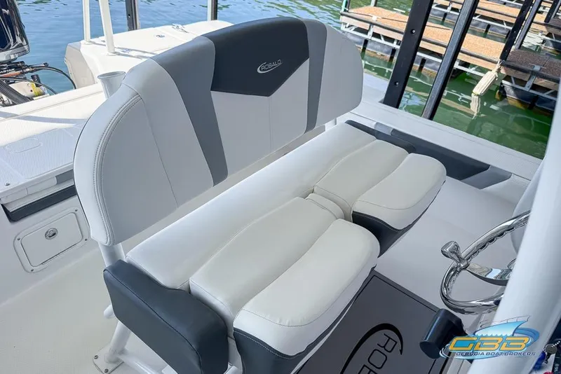 Slide: The Image of 2023 Robalo 226 Cayman boat interior with cushioned seating and steering wheel. - 14