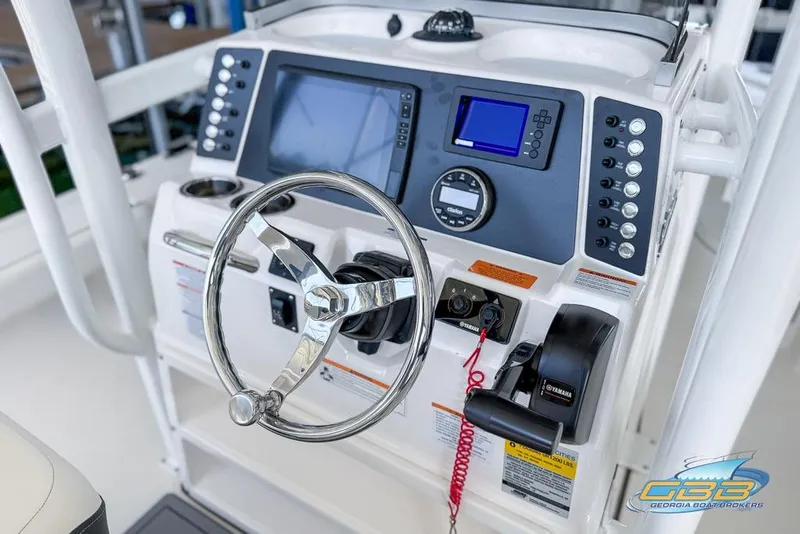 Slide: The Image of 2023 Robalo 226 Cayman boat dashboard with steering wheel and control panel. - 16