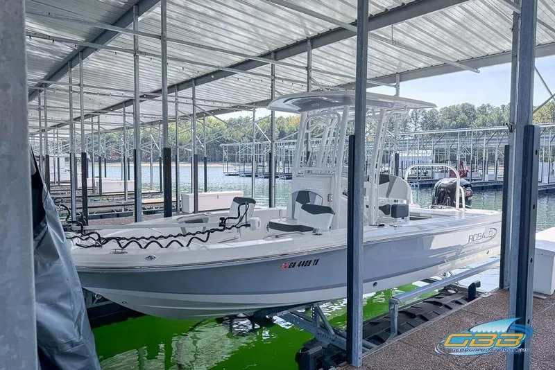 Slide: The Image of 2023 Robalo 226 Cayman boat docked in a marina with covered roof. - 3