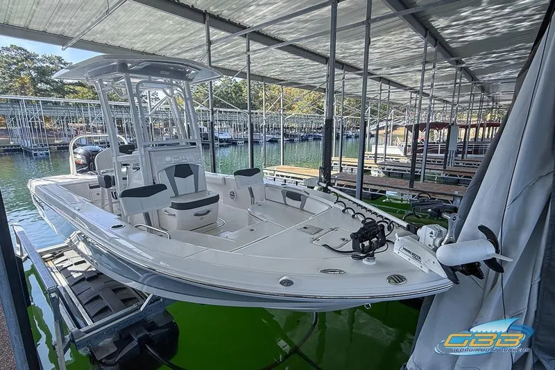 Slide: The Image of 2023 Robalo 226 Cayman boat docked in a covered marina, showcasing sleek design. - 4