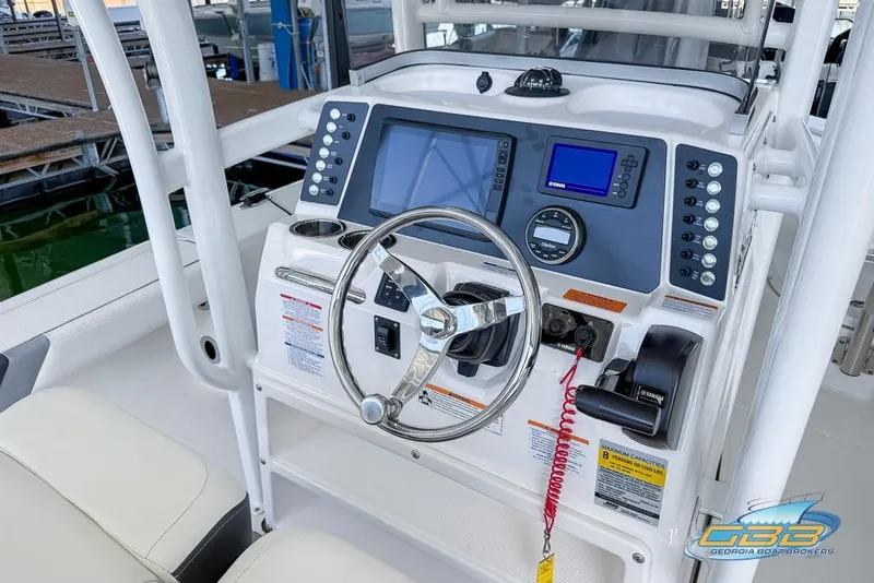 Slide: The Image of 2023 Robalo 226 Cayman boat dashboard with steering wheel and navigation controls. - 41