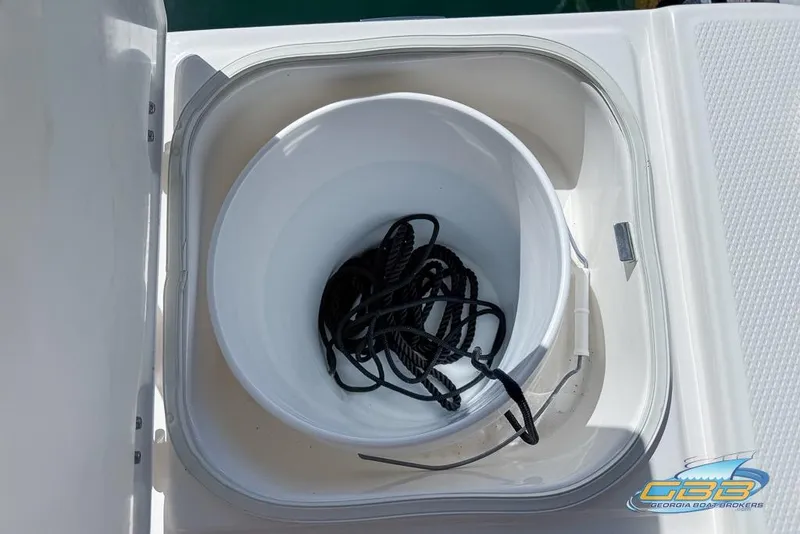 Slide: The Image of 2023 Robalo 226 Cayman boat storage compartment with rope inside a white bucket. - 44