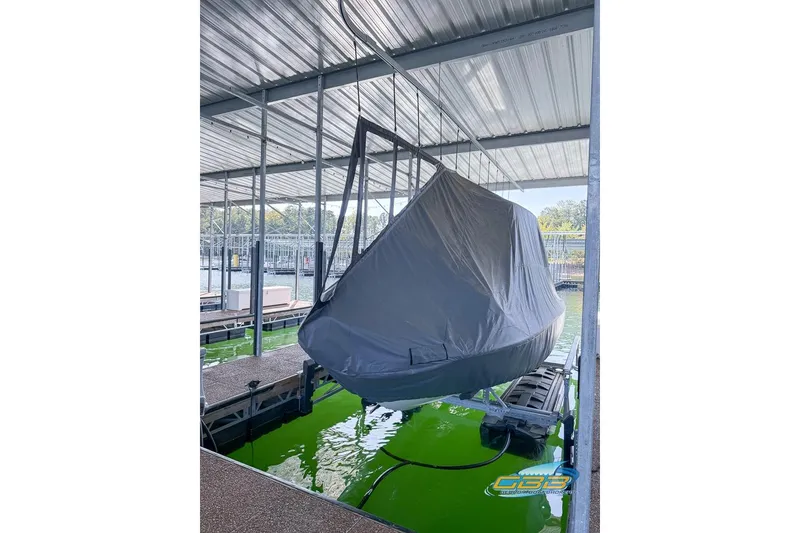 Slide: The Image of 2023 Robalo 226 Cayman boat covered and docked in a marina. - 49