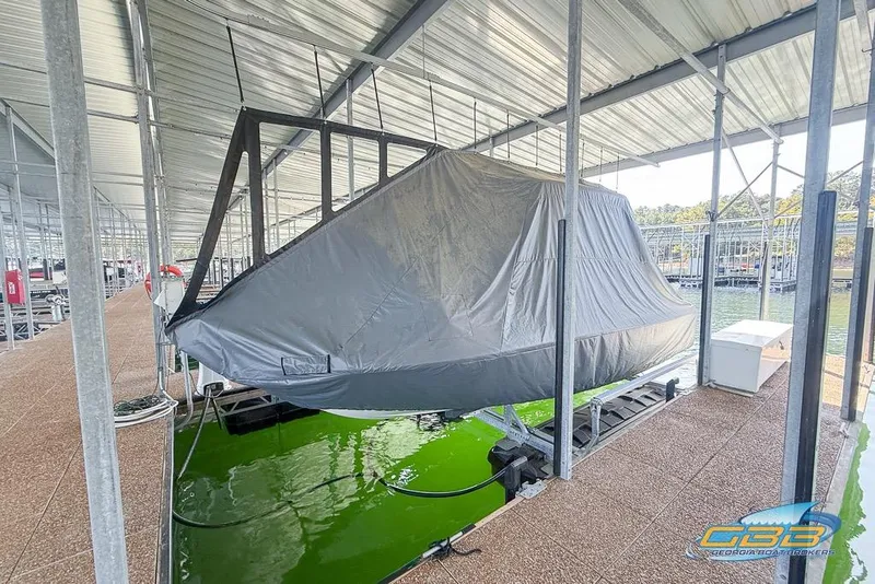 Slide: The Image of 2023 Robalo 226 Cayman boat covered and docked in a marina. - 52