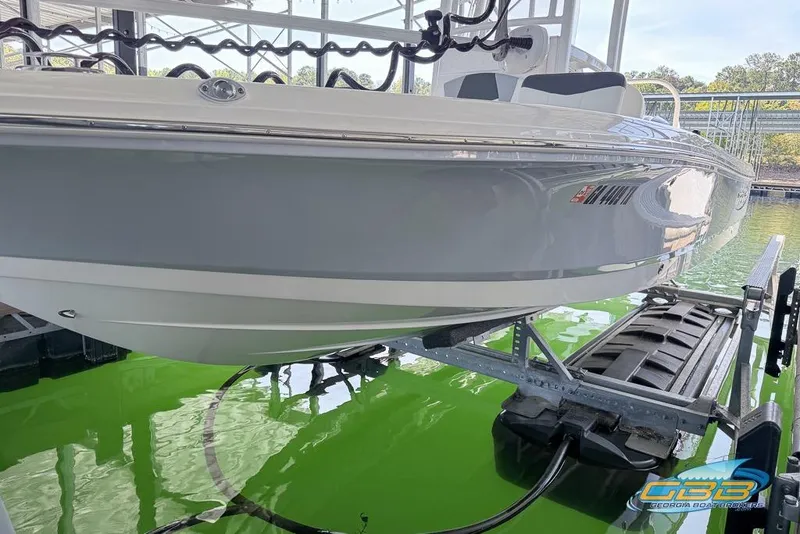 Slide: The Image of 2023 Robalo 226 Cayman boat on lift, docked over green water. - 6
