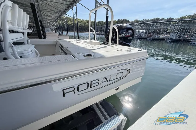 Slide: The Image of 2023 Robalo 226 Cayman boat docked at marina, featuring sleek design and Yamaha engine. - 7