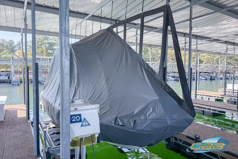 Slide: The Image of Covered 2023 Robalo 226 Cayman boat in marina storage, suspended on lift. - 9