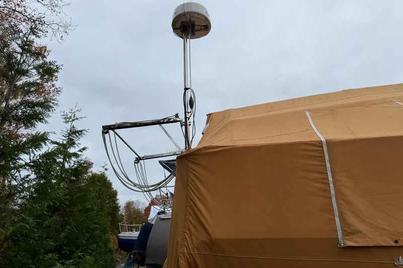 Slide: The Image of Catalina 36 MkII sailboat, 2006 model, covered with a tan tarp, surrounded by trees. - 13