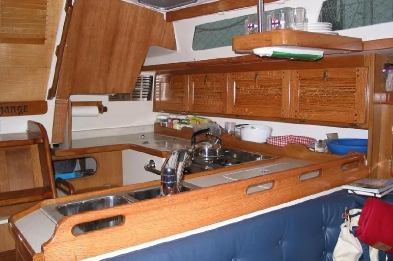 Slide: The Image of Interior of 2006 Catalina 36 MkII sailboat galley with wooden cabinetry and modern amenities. - 53