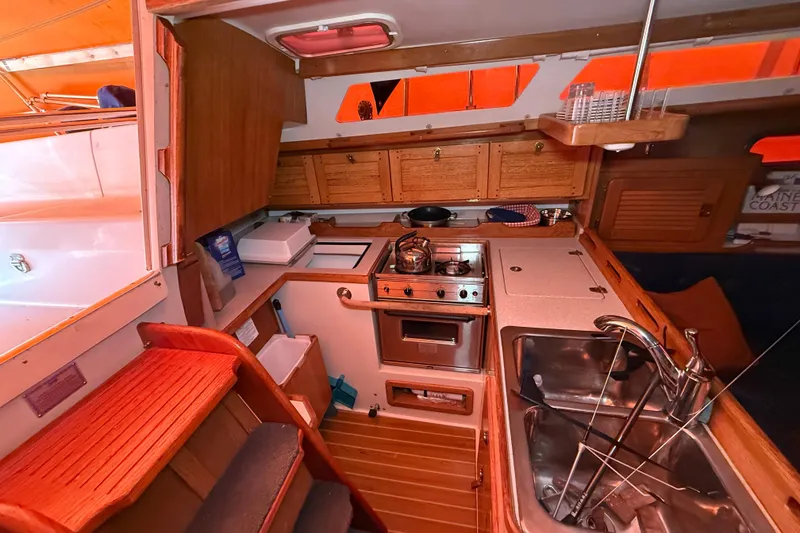 Slide: The Image of Cozy kitchen area in a 2006 Catalina 36 MkII sailboat with wooden cabinetry and stainless steel sink. - 54