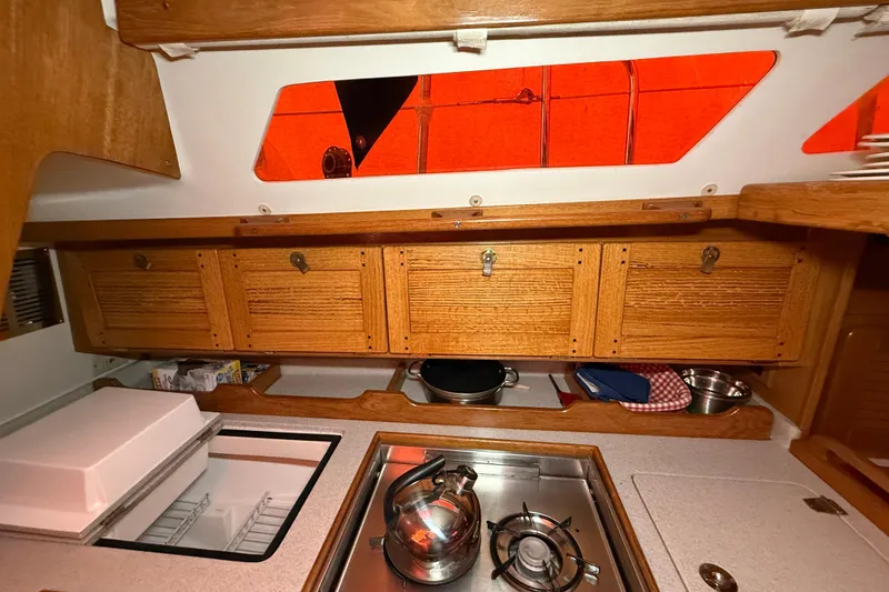Slide: The Image of Cozy galley kitchen in 2006 Catalina 36 MkII sailboat with wooden cabinets and stainless steel stove. - 58