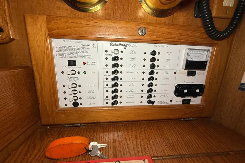 Slide: The Image of Electrical control panel of a 2006 Catalina 36 MkII yacht with various switches and keys. - 71