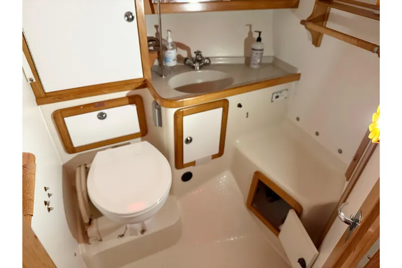 Slide: The Image of 2006 Catalina 36 MkII yacht bathroom with toilet, sink, and wooden cabinetry. - 76