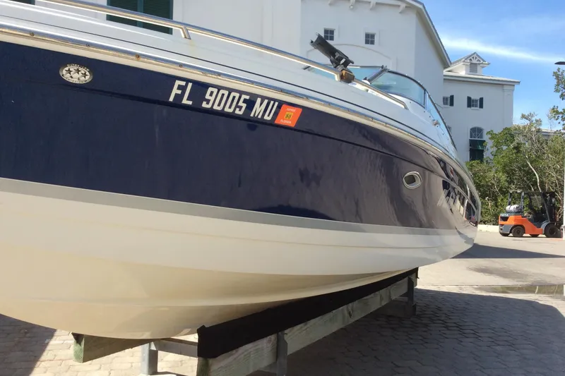 Slide: The Image of 2005 Formula 260 Bowrider boat on trailer, blue and white hull, parked outdoors. - 3