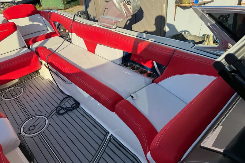 Slide: The Image of 2018 MasterCraft X46 boat interior with red and white seating and cup holders. - 9