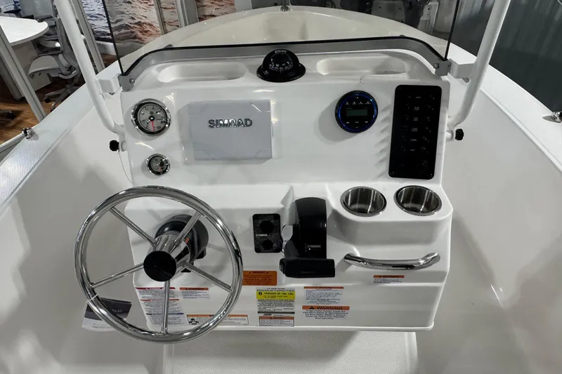 Slide: The Image of 2026 Robalo R160 Center Console boat dashboard with steering wheel and Simrad display. - 5