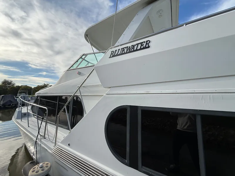 Slide: The Image of 1996 Bluewater Yachts 643 Motor Yacht docked, showcasing sleek design and elegant structure. - 11