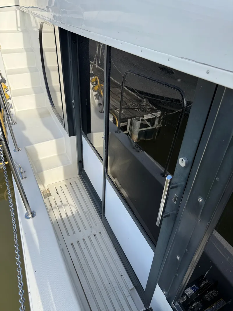 Slide: The Image of 1996 Bluewater Yachts 643 Motor Yacht deck with sliding glass doors and railing. - 18