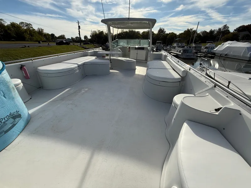Slide: The Image of 1996 Bluewater Yachts 643 Motor Yacht deck with seating, docked under a blue sky. - 20
