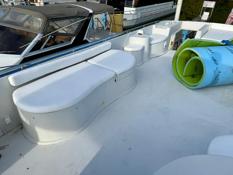 Slide: The Image of 1996 Bluewater Yachts 643 Motor Yacht deck with white seating and rolled aqua mat. - 22