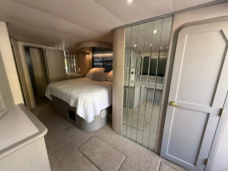 Slide: The Image of Luxurious bedroom interior of 1996 Bluewater Yachts 643 Motor Yacht with mirrored closet and cozy bed. - 27