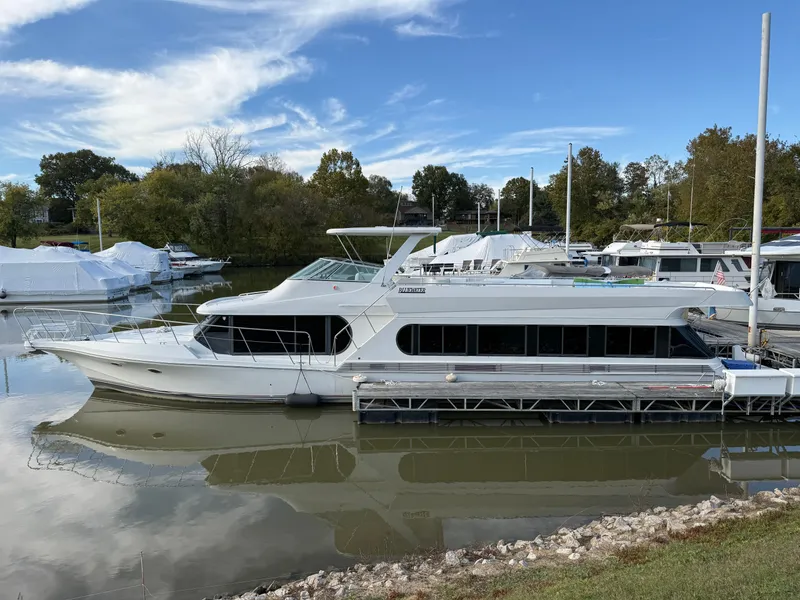 Slide: The Image of 1996 Bluewater Yachts 643 Motor Yacht docked on a calm river under a clear sky. - 3