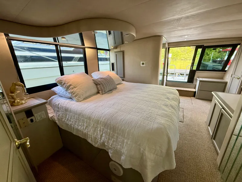 Slide: The Image of Luxurious bedroom interior of 1996 Bluewater Yachts 643 Motor Yacht with large windows and cozy bedding. - 30