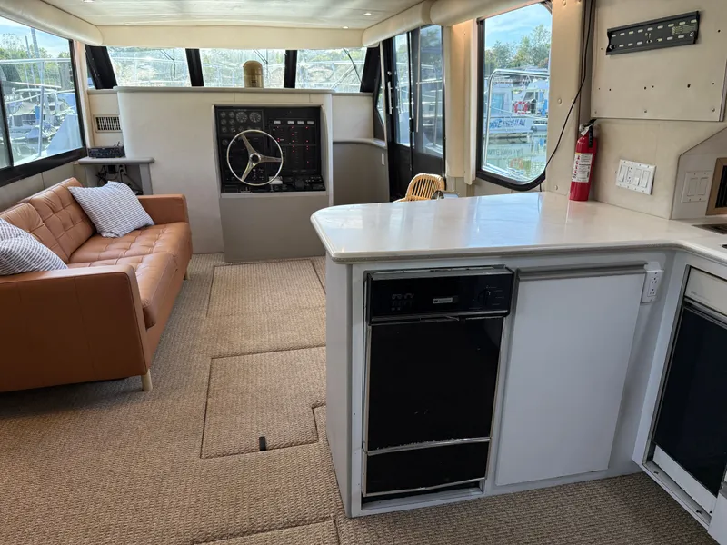 Slide: The Image of Interior of 1996 Bluewater Yachts 643 Motor Yacht with helm, sofa, and kitchenette. - 40