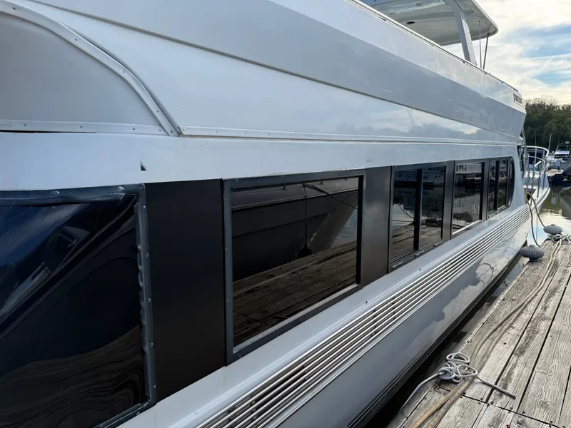 Slide: The Image of 1996 Bluewater Yachts 643 Motor Yacht docked, showcasing sleek design and large windows. - 7
