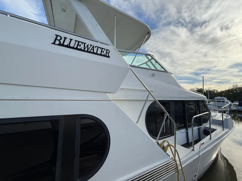 Slide: The Image of 1996 Bluewater Yachts 643 Motor Yacht docked under a cloudy sky. - 8