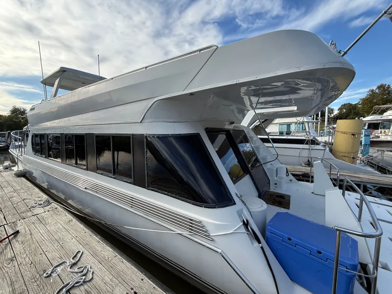 Slide: The Image of 1996 Bluewater Yachts 643 Motor Yacht docked, showcasing sleek design and spacious upper deck. - 9