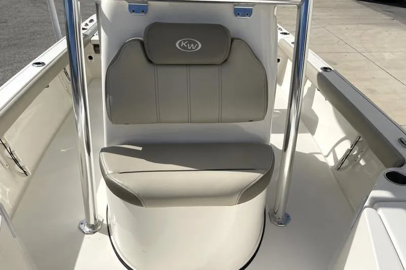 Slide: The Image of 2024 Key West 210 Bay Reef boat with T-top and rod holders, under clear blue sky. - 27