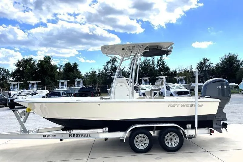 Slide: The Image of 2024 Key West 210 Bay Reef boat on trailer under blue sky. - 4